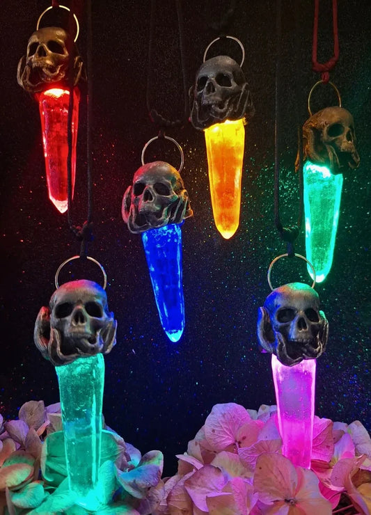 A handmade fantasy skull and leaf necklace featuring an enchanted crystal pendant that glows with an integrated LED light source.