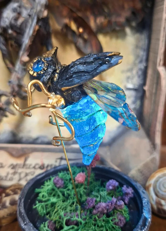 Artisan fantasy insect sculpture displayed inside its protective glass dome with moss, styled as a Cabinet of Curiosities or Wunderkammer decor piece.